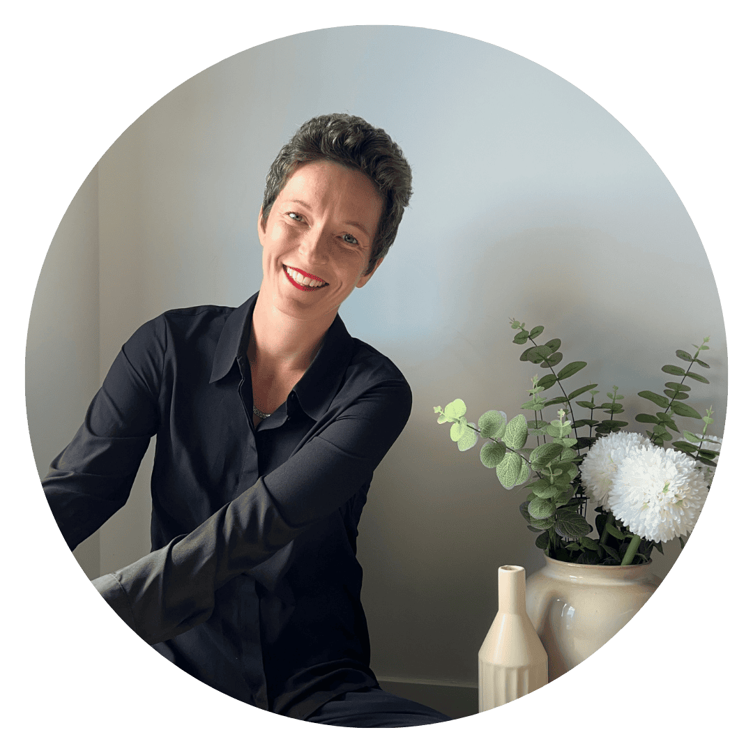 Frau sitzt entspannt in einem hellen Raum und lächelt in die Kamera – persönliche Technik-Begleiterin für Onlinebusiness und digitale Prozesse.