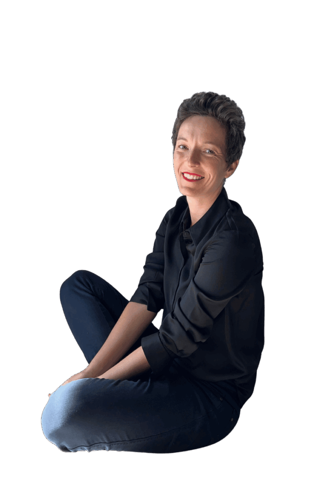 Frau sitzt entspannt auf dem Boden und lächelt in die Kamera – Technik-Begleiterin für Onlinekurse und Onlinebusiness.