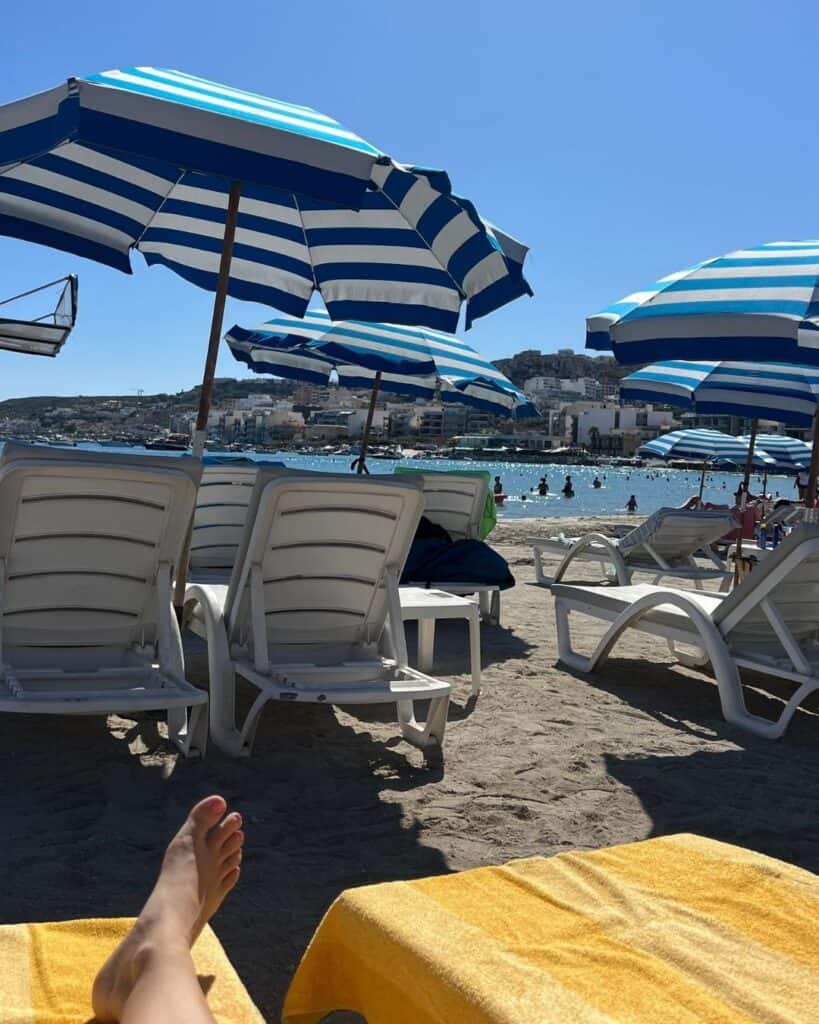 Blick vom Strand mit Liegen und Sonnenschirmen am Meer – Arbeiten von der Sonne aus und ortsunabhängiges Online-Business.